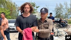 FILE - Seorang polisi Thailand mengawal Daniel Sancho Bronchalo dari Spanyol karena dicurigai membunuh dan memutilasi seorang ahli bedah Kolombia dari pulau Koh Phagnan ke pengadilan Pulau Koh Samui, Thailand selatan, Senin, 7 Agustus 2023. (AP/Somkeat Ruksaman)