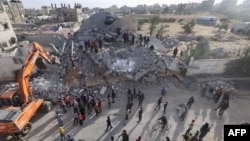 21일 이스라엘 군의 공습으로 무너진 가자지구 남부 라파의 건물에서 구조대원들과 민간인들이 구조작업을 진행중이다.