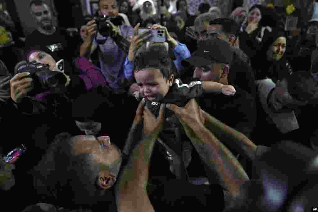 Mourners carry 6-month-old Abdullah Sheikh Khalil during the funeral of his father, Ahmed Sheikh Khalil, 20 and Wael Misha, 18, both killed by an airstrike in the occupied West Bank, at the family house in the refugee Camp of Balata, in Nablus.