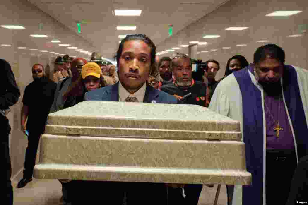 State Rep. Justin Jones carries a coffin representing one of the victims of the Covenant School shooting into the state capitol, in Nashville, Tennessee, April 17, 2023.