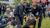 A protester is dragged away by police officers during a pro-Palestinians demonstration on the campus of Berlin's Free University, in Berlin, Germany, May 7, 2024.