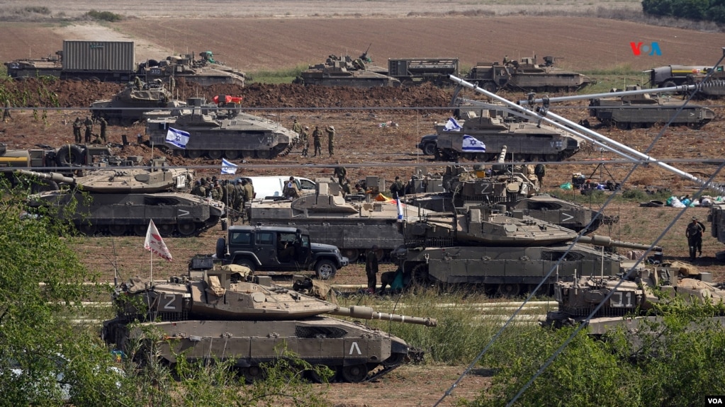 Cientos de tanques, vehículos blindados, camiones cisterna se pueden ver desde la carretera en la frontera sur de Israel. [Foto: Alejandro Ernesto, VOA]. 