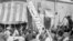 FILE - A crowd of demonstrators tears down the Iran Party's sign from the front of the headquarters in Tehran on Aug. 19, 1953, during the CIA-backed coup that ousted Prime Minister Mohammad Mossadegh and his government. 