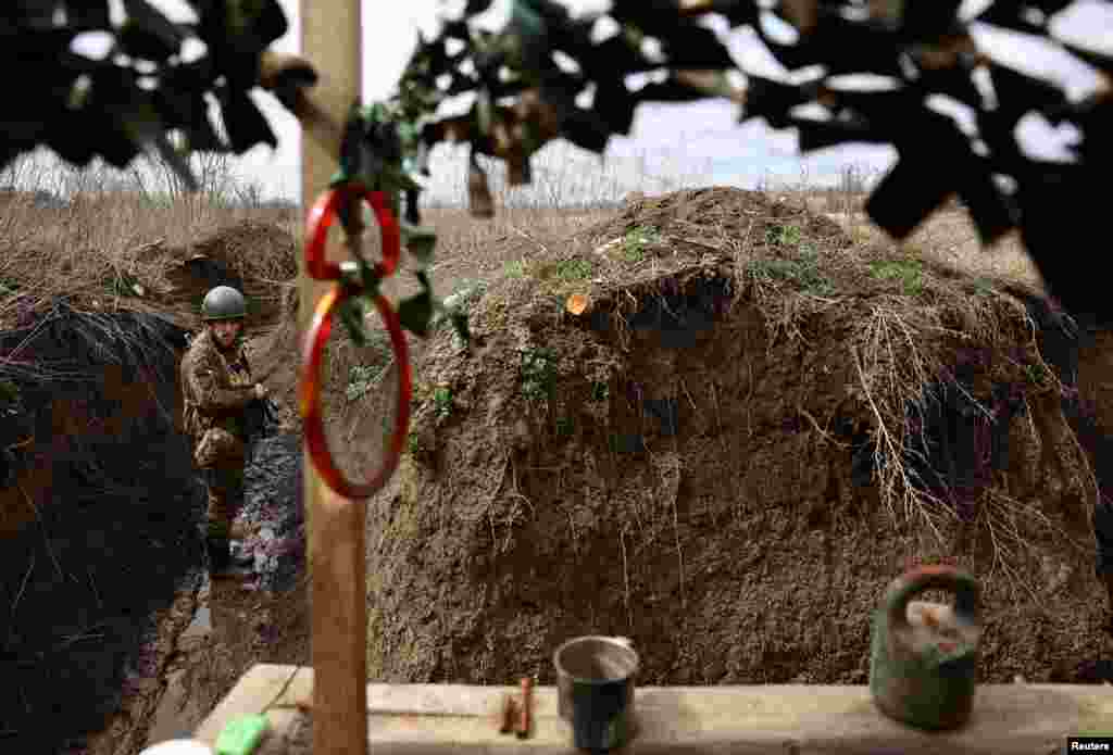 Ukrainian service man Yuzik of the 24th brigade walks through the trenches at the front line, amid Russia’s attack on Ukraine, near Niu York, Donetsk region, Ukraine.