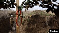 Ukrainian service man Yuzik of the 24th brigade walks through the trenches at the front line, amid Russia’s attack on Ukraine, near Niu York, Donetsk region, Ukraine.