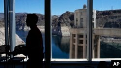 FILE - People attend a news conference on Lake Mead at Hoover Dam, April 11, 2023, in Nevada. Arizona, California and Nevada on May 22, proposed a deal to significantly cut water use from the drought-stricken Colorado River over the next three years.