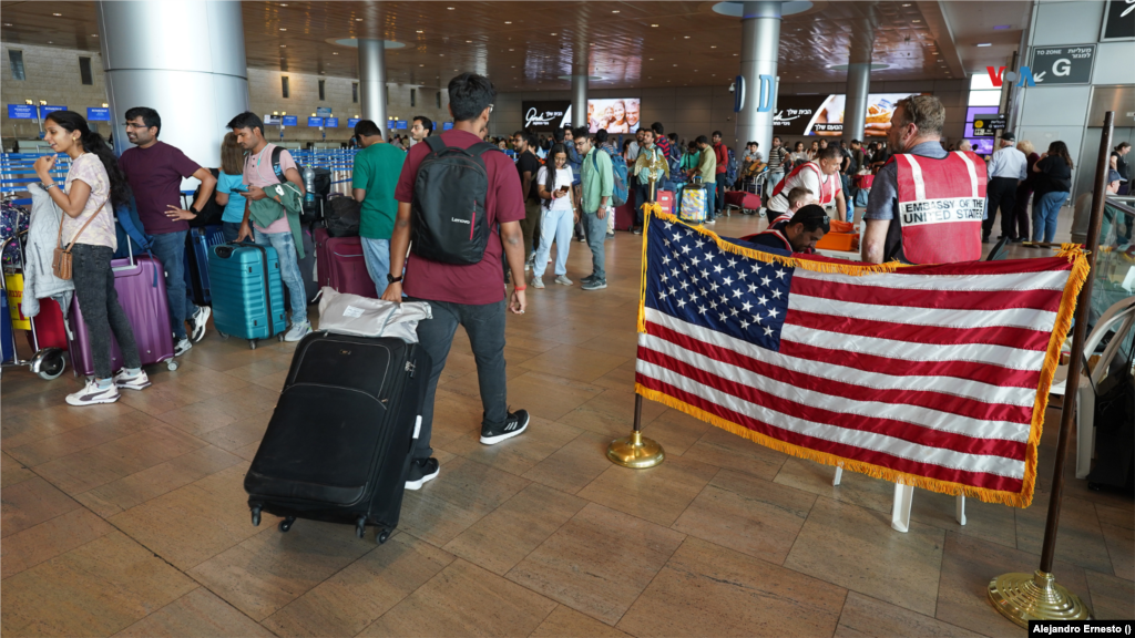 Una bandera de Estados Unidos puede verse junto a un puesto temporal de la embajada de ese país en Israel, en el aeropuerto internacional de Telaviv, desde donde turistas y ciudadanos extranjeros esperan vuelos repatriación para regresar a sus naciones desde un Israel en guerra, el 13 de octubre de 2023.