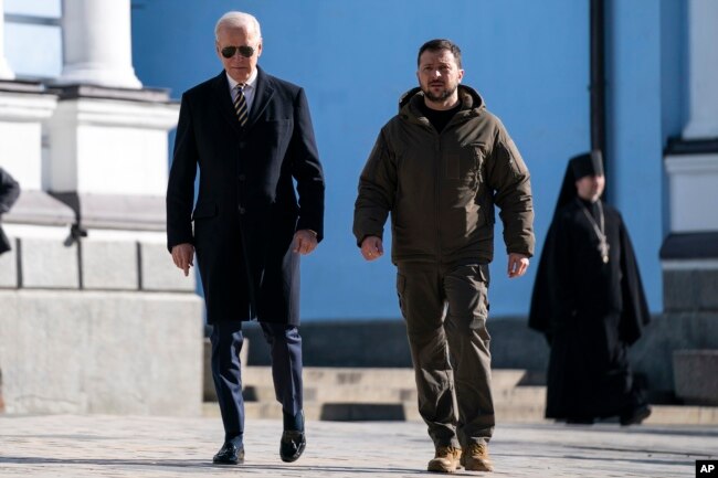 US President Joe Biden, left, walks with Ukrainian President Volodymyr Zelenskyy at St. Michael's Golden-Domed Cathedral during an unannounced visit, in Kyiv, Ukraine, Monday, Feb. 20, 2023. (AP Photo/Evan Vucci)