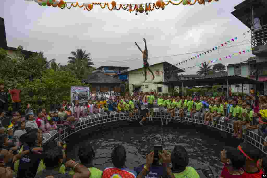 A boy jumps as he attempts to break the Dahi handi, an earthen pot filled with curd, hanging above a well, as part of Janmashtami festival in Kurdus village, Raigad district in the western Indian state of Maharashtra.