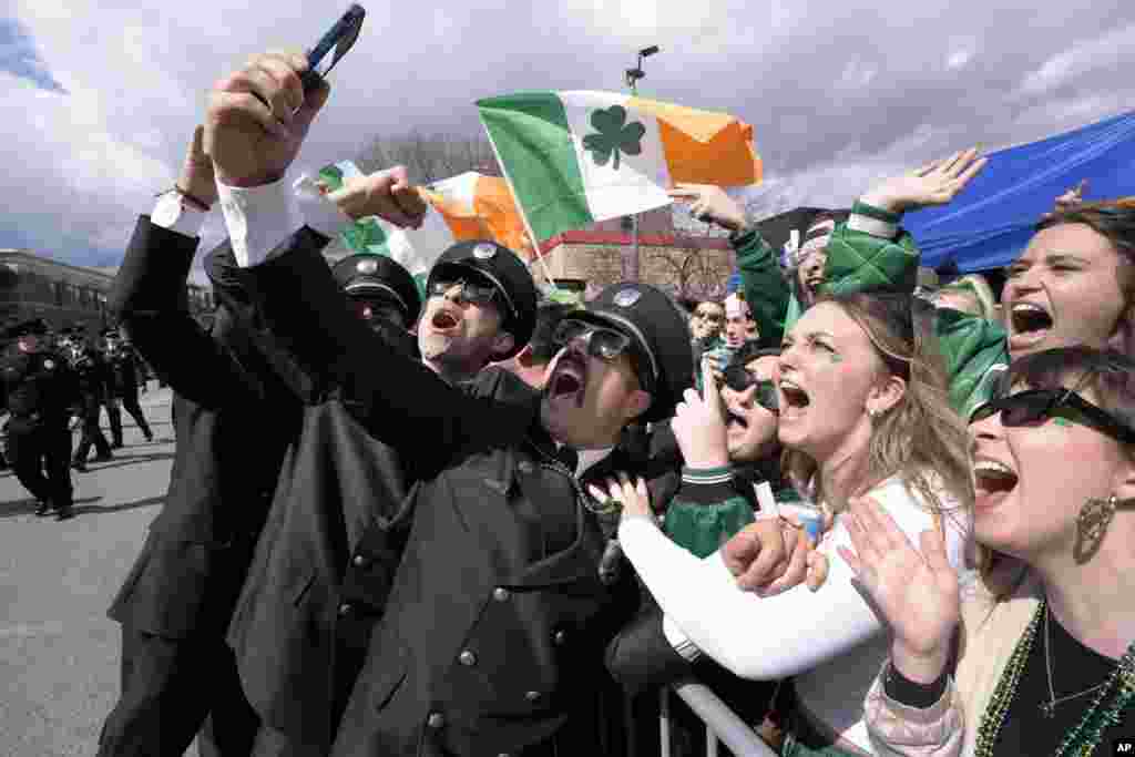 A group of firemen from around the United States pose for a selfie with spectators while marching in the St. Patrick&#39;s Day parade, March 17, 2024, in South Boston neighborhood, Massachusetts.