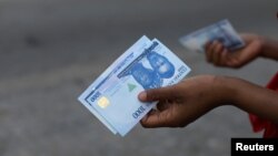 FILE — A person holds a 1000 Naira note as the Central Bank of Nigeria releases the notes to the public through the banks in Abuja, Nigeria, on December 15, 2022. 