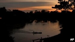 FILE - A small boat crosses the Acre River near the Chico Mendes Extractive Reserve, in Xapuri, Acre state, in Brazil's Amazon rainforest, Dec. 7, 2022.