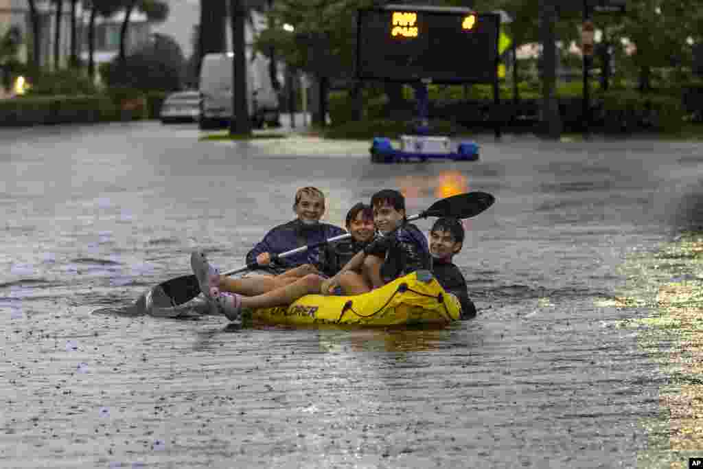 Los residentes viajan en balsa por una calle inundada causada por las fuertes lluvias en Sunny Isles, Florida.