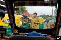 Preethi, mencari penumpang untuk naik becak listriknya di jalan yang sibuk di Bengaluru, India, Rabu, 12 Juli 2023. (AP/Aijaz Rahi)