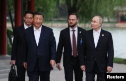 16일 블라디미르 푸틴 러시아 대통령과 시진핑 중국 국가주석이 중국 베이징 중난하이 공원에서 열린 다도회에 참석하기 위해 걸어가고 있다.