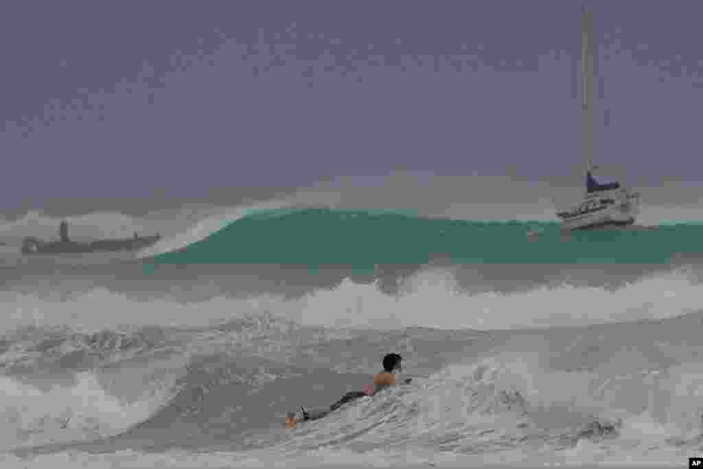 A surfer braves the waves in Carlisle Bay as Hurricane Beryl passes through Bridgetown, Barbados.