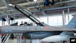 Ukrainian President Volodymyr Zelenskyy, left, and Denmark's Prime Minister Mette Frederiksen sit in a F-16 fighter jet at Skrydstrup Airbase, in Vojens, Denmark, Aug. 20, 2023.