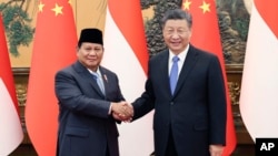 Chinese President Xi Jinping, at right, shakes hands with Indonesian President-elect Prabowo Subianto at the Great Hall of the People in Beijing on April 1, 2024, in this photo released by Xinhua News Agency.