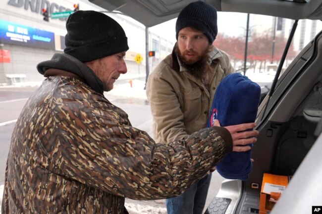 Will Compton, right, gives Luke Hall a blanket, Jan. 18, 2024, in Nashville, Tennessee.