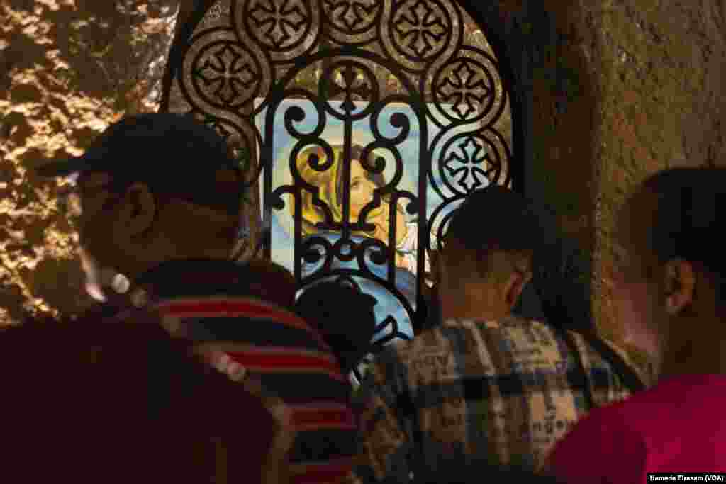 Pilgrims recite prayers and wishes before another luminous shrine deep inside the Virgin Mary Monastery, a sacred site of ongoing refuge.