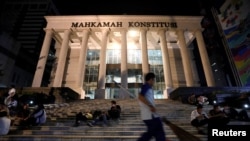 Seorang petugas kebersihan melintas di depan gedung Mahkamah Konstitusi di Jakarta, 24 Mei 2019. (Foto: Willy Kurniawan/Reuters)