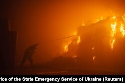 In this photo by Pavlo Petrov and the Press Service of the State Emergency Service of Ukraine, a firefighter works at a tobacco factory damaged during Russia's attack on Ukraine, in Kyiv, May 28, 2023.