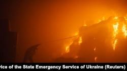 In this photo by Pavlo Petrov and the Press Service of the State Emergency Service of Ukraine, a firefighter works at a factory hit during Russia's attacks on Ukraine, in Kyiv, May 28, 2023.