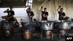 Local volunteers of the World Central Kitchen cook meals to be distributed to needy Palestinians in Rafah in the southern Gaza Strip. (Photo by AFP)