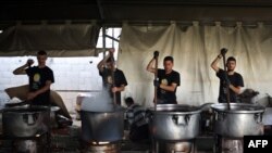 Relawan lokal dari organisasi World Central Kitchen memasak di dapur umum untuk sejumlah warga Palestina di Rafah, selatan Jalur Gaza, pada 3 Mei 2024. (Foto: AFP)