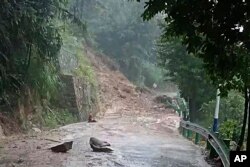 In this photo released by Xinhua News Agency, a landslide blocks a road in Shouyue Town of Nanyue District, Hengyang City, central China's Hunan Province on July 28, 2024.