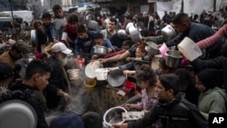 Warga Palestina antre untuk mendapatkan makan di Rafah, Jalur Gaza, 21 Desember 2023. (Foto: AP)