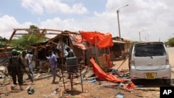 Tentara bersenjata Kenya memeriksa lokasi ledakan di dekat kantor polisi di Mandera, Kenya, Senin, 25 Maret 2024. (AP/Omar Noor)