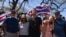 Community organizer Tiare Lawrence, second from right, is comforted by Archie Kalepa as they sing a song during a news conference with Lahaina, Hawaii, residents affected by the deadly wildfire in Lahaina, Aug. 18, 2023.