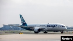 FILE - A WestJet Boeing 787-9 Dreamliner taxis along a runway at Toronto Pearson Airport in Mississauga, Ontario, Canada, April 28, 2021.
