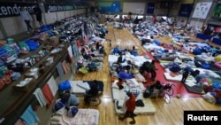 People who have been evacuated from flooded areas rest at a gym used as a shelter in Porto Alegre, Rio Grande do Sul state, Brazil, May 10, 2024.