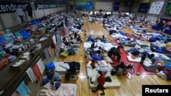 Warga yang dievakuasi dari wilayah yang terdampak banjir, beristirahat di tempat penampungan di Porto Alegre, negara bagian Rio Grande do Sul, Brazil, Jumat, 10 Mei 2024. (Foto: Diego Vara/Reuters)