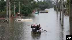 Sejumlah warga menggunakan perahu kecil mengarungi banjir setelah hujan lebat mengguyur Kota Canoas, di negara bagian Rio Grande do Sul, Brazil, Jumat, 10 Mei 2024. (Foto: Andre Penner/AP Photo)