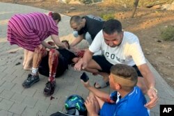 Residents rush to help injured children moments after a rocket attack hit a soccer field in the Druze town of Majdal Shams in the Israeli-controlled Golan Heights, July 27, 2024.