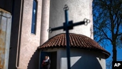 Christian Orthodox worshippers leave the chapel basement after attending a service at the Church of the Intercession of the Blessed Virgin Mary in Lypivka near Lviv, Ukraine, April 28, 2024.