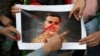 FILE - Afghan nationals paint over a picture of Pakistan's former spy chief, Faiz Hameed, as they hold a protest near a police station in New Delhi, Sept. 10, 2021. Pakistan announced on Aug. 12, 2024, the arrest of the retired general. 