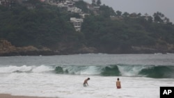 Tourists swim in Acapulco, Mexico, Oct. 24, 2023. Hurricane Otis has strengthened from tropical storm to a major hurricane in a matter of hours.