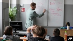 Arkadiusz Korporowicz teaches history to fifth-graders at Primary School number 223 in Warsaw, Poland, April 3, 2024.