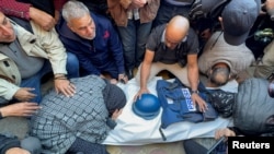 Mourners attend the funeral of Al Jazeera cameraman Samer Abu Daqqa, who according to the Arabic broadcaster, was killed by an Israeli drone strike Friday while reporting on the bombing of a school sheltering people in Khan Younis in the Gaza Strip, Dec. 16, 2023.