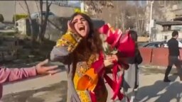 This image grab from a UGC video posted outside Iran on March 15, 2023, shows Iranian activist and journalist Sepideh Gholian walking with a bouquet of flowers outside the walls of Evin prison in Tehran, following her release. She was later rearrested.