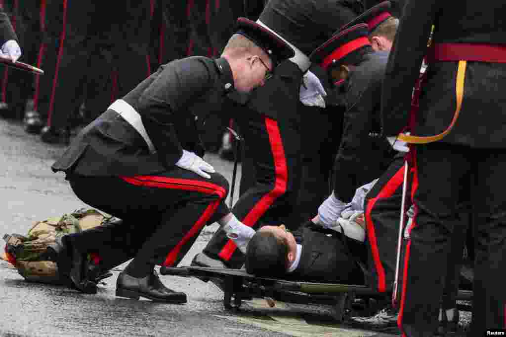 Los policías atienden a un compañero que se desmayó en Westminster el día de la coronación del rey Carlos de Gran Bretaña.