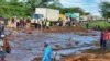 Orang-orang berkumpul di jalan utama setelah bendungan jebol, di Desa Kamuchiri Mai Mahiu, Kabupaten Nakuru, Kenya, Senin, 29 April 2024. Polisi di Kenya mengatakan sedikitnya 40 orang tewas setelah bendungan runtuh di bagian barat negara itu. (AP)