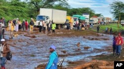 Orang-orang berkumpul di jalan utama setelah bendungan jebol, di Desa Kamuchiri Mai Mahiu, Kabupaten Nakuru, Kenya, Senin, 29 April 2024. Polisi di Kenya mengatakan sedikitnya 40 orang tewas setelah bendungan runtuh di bagian barat negara itu. (AP)