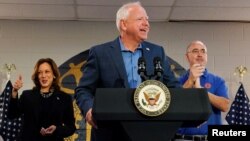 Democratic vice presidential candidate, Minnesota Gov. Tim Walz speaks during a campaign event next to Vice President and Democratic presidential candidate Kamala Harris, left, at the United Auto Workers Local 900 in Wayne, Mich., Aug. 8, 2024.