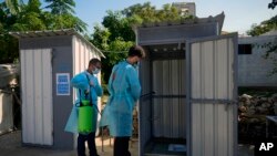 UNICEF health care workers sanitize bathrooms as part of a cholera outbreak containment response, at a Syrian refugee camp in Bhanine village, in the northern Akkar province, Lebanon, Oct. 18, 2022. 