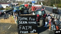 Farmers block A63 highway to protest over taxation and declining income, near Bayonne, on Jan. 23, 2024. The sign says "Our end will be your hunger." 